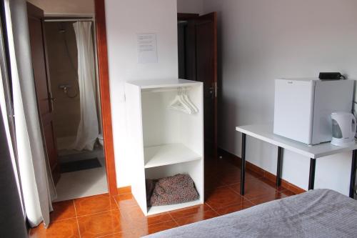 Cette chambre comprend une armoire blanche et un miroir. dans l'établissement El sueño - Le rêve, à San Bartolomé