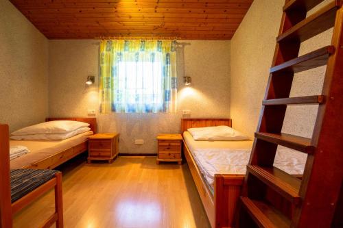 ein kleines Zimmer mit 2 Betten und einem Fenster in der Unterkunft Ferienwohnpark Immenstaad am Bodensee Satteldachhaus Typ 10 SDS 048 in Immenstaad am Bodensee
