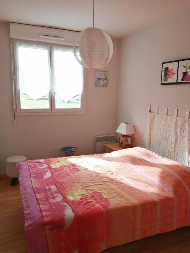 - une chambre avec un lit et une couverture colorée dans l'établissement Nid douillet au calme, à Larche