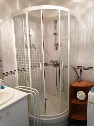 une douche avec une porte vitrée dans une salle de bain dans l'établissement Nid douillet au calme, à Larche