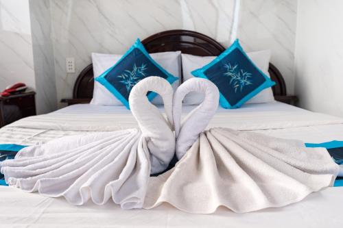 two swans wrapped in towels sitting on a bed at Thanh Lan Hotel in Ho Chi Minh City