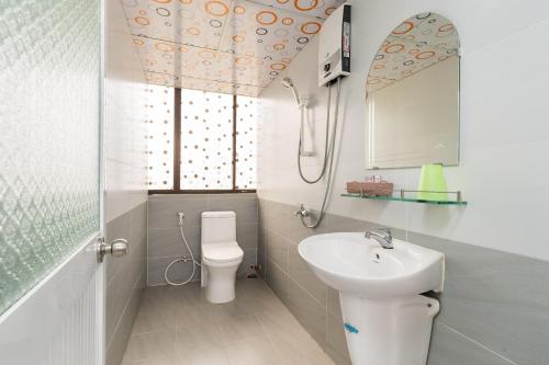 a bathroom with a sink and a toilet and a mirror at Thanh Lan Hotel in Ho Chi Minh City