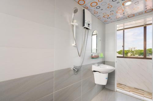a white bathroom with a sink and a shower at Thanh Lan Hotel in Ho Chi Minh City