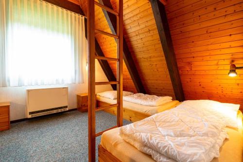 une chambre avec deux lits superposés et une fenêtre dans l'établissement Ferienwohnpark Immenstaad am Bodensee Nurdachhaus Typ 8 NDT 032, à Immenstaad am Bodensee