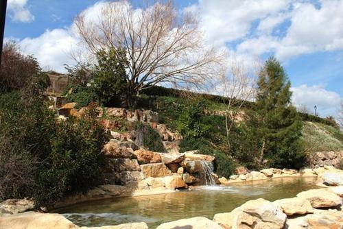 a river with a waterfall and rocks and trees at Molí Fariner Casa Rural in Agullent