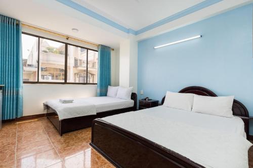 a bedroom with a bed and a chair and a window at Thanh Lan Hotel in Ho Chi Minh City