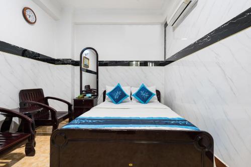 a bedroom with a bed with blue pillows at Thanh Lan Hotel in Ho Chi Minh City