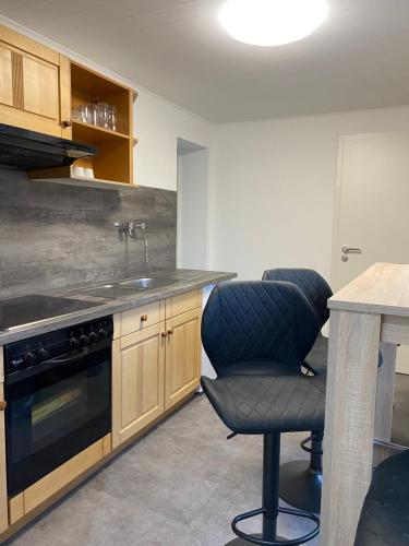 a kitchen with a table and two chairs and a sink at Ferienwohnung H&M Immobilien Hettstedt in Hettstedt