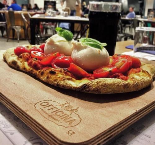 a pizza sitting on top of a wooden cutting board at Hotel Panorama in Cambiano