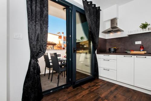 a kitchen with sliding glass doors and a table with chairs at Deluxe Apartments A&A in Rovinj