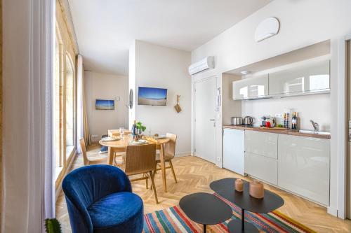 a kitchen and a living room with a table and chairs at Les Suites de Saint Amand in Bordeaux