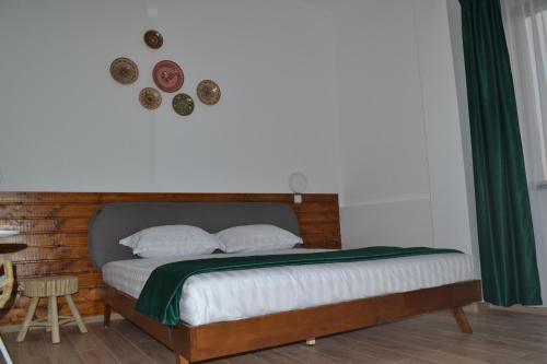 a bedroom with a bed with a wooden headboard at Jianca Pensiune Agroturistică in Bogea