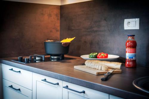 a kitchen counter with a stove with a cutting board and food at Deluxe Apartments A&A in Rovinj