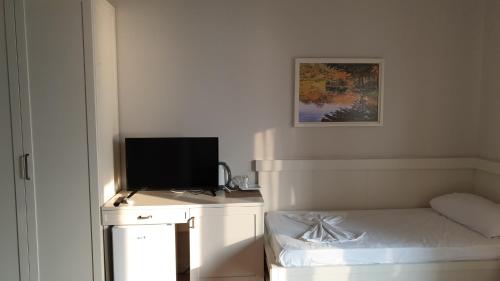 a room with a bed and a television on a desk at Joel Residence in Durrës