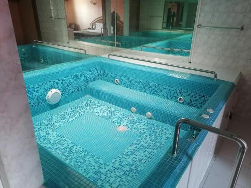 a blue tiled bath tub in a bathroom at Hotel Puerta del Sol in Toluca