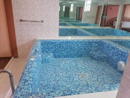 a blue tiled bath tub in a bathroom at Hotel Puerta del Sol in Toluca