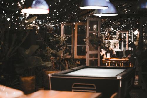 a room with a table and plants and lights at Letana Hotel in Bang Phli