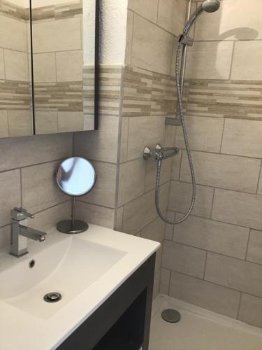 La salle de bains est pourvue d'une douche et d'un lavabo blanc. dans l'établissement Face à la mer, à Saint-Aygulf