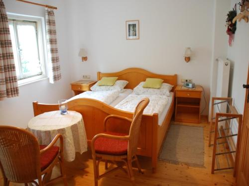 翁特沃森的住宿－Gästehaus Stoanerhof，卧室配有一张床和一张桌子及椅子