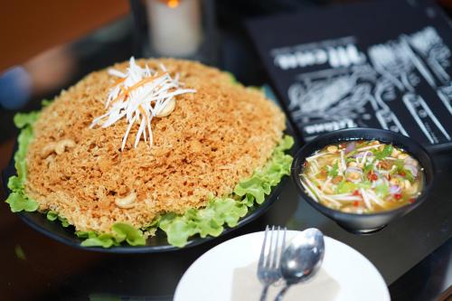 a sandwich on a table with a bowl of salad at Letana Hotel in Bang Phli