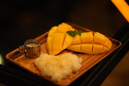 a tray of mangoes and rice on a table at Letana Hotel in Bang Phli