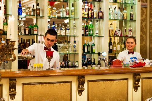two people behind a bar with a bartender at Spa Hotel Gloria in Przemyśl