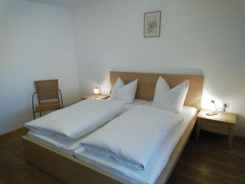 Ferienwohnung Rappl في شليكينغ: سرير كبير بملاءات ووسائد بيضاء