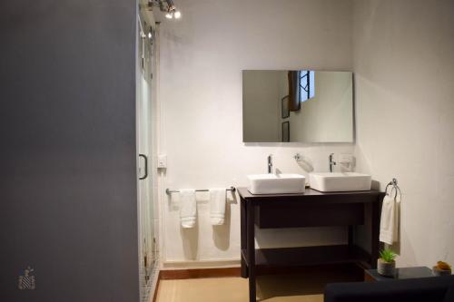 a bathroom with two sinks and a mirror at Quinta Alhóndiga Galindo Hotel Boutique in Cholula