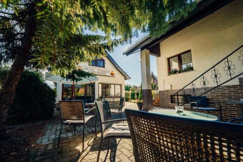 a patio with chairs and tables and a building at Hotel-Pension Hafemann in Senftenberg