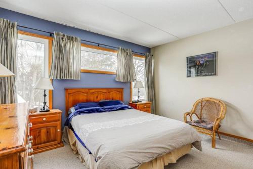 Un dormitorio con una cama grande y una ventana. en Ski In Out Mountainside Chalet 83001, en Blue Mountains