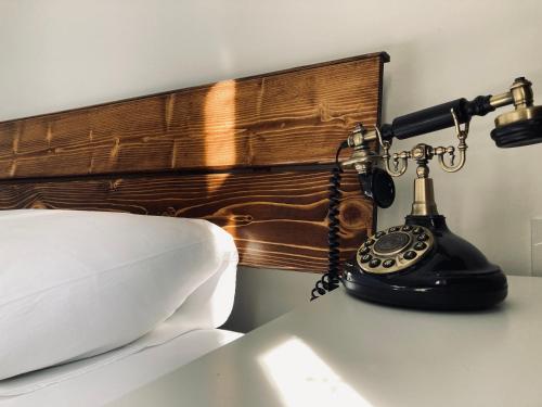 a telephone sitting on a table next to a bed at Hotel Erol - Adult Only in Ayvalık