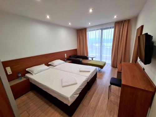una camera d'albergo con letto e TV di Family Hotel Serenity Palace ad Ahtopol
