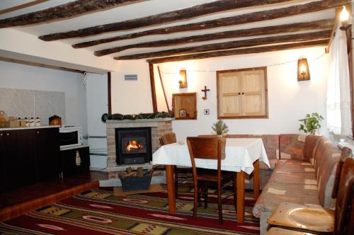 sala de estar con mesa y chimenea en The House in Shipka, en Shipka