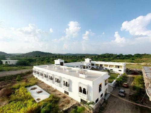 an aerial view of a white building in a field at Vijayam Resort in Nāthdwāra