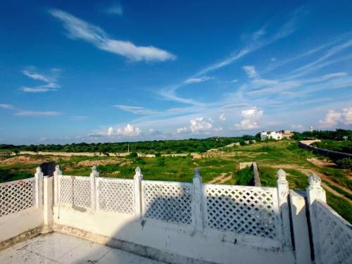 a white balcony with a view of a field at Vijayam Resort in Nāthdwāra