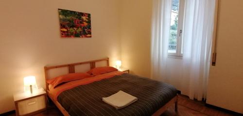 um quarto com uma cama com almofadas laranja e uma janela em Casa Avezza em Omegna