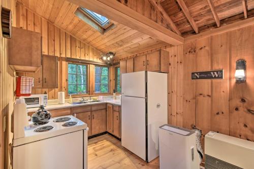cocina con electrodomésticos blancos y paredes de madera en Sprucewold Boothbay Harbor Cottage with Deck, en Boothbay Harbor
