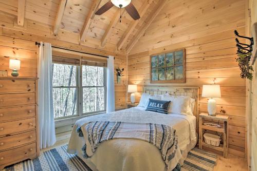 a bedroom with a bed in a wooden cabin at Couples Getaway Cabin by Hiking and Waterfalls! in Cherry Log