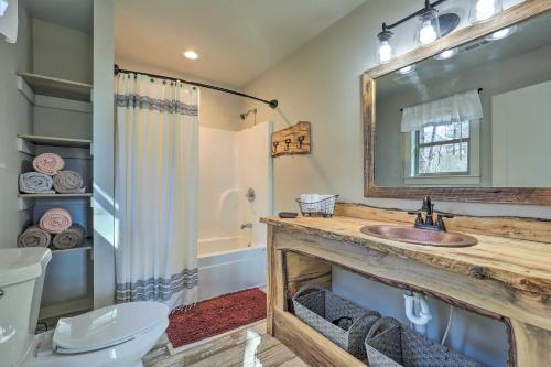 ein Badezimmer mit einem Waschbecken, einem WC und einem Spiegel in der Unterkunft Creek-View Getaway with Deck, Yard, and Fire Pit! in Summerville