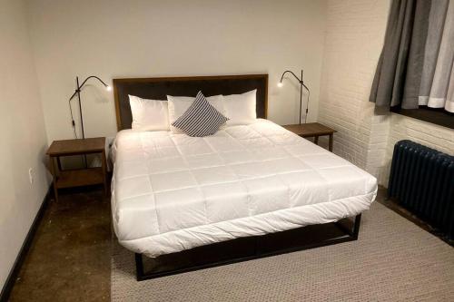 a bedroom with a large bed with white sheets and pillows at 3E-*New* Apt 10 min to Children’s Hospital, slps 4 in Pittsburgh