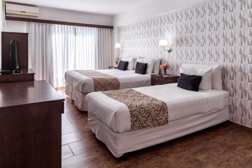 a hotel room with two beds and a television at Ker Belgrano Hotel in Buenos Aires