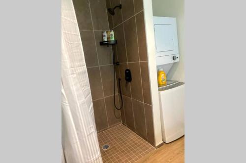 a shower in a bathroom with a washer at 3E-*New* Apt -5 min from Downtown, 3E, Sleeps 6 in Pittsburgh