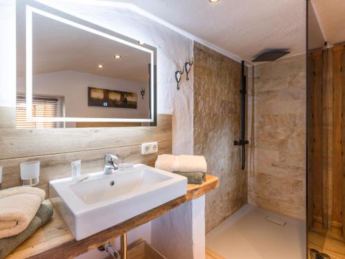 La salle de bains est pourvue d'un lavabo et d'un miroir. dans l'établissement Chalet Hüttenzauber, à Kirchberg in Tirol
