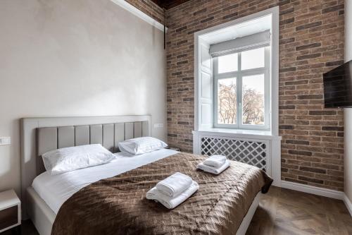 a bedroom with a bed with two towels on it at Grand Rynok Square apartment in Lviv