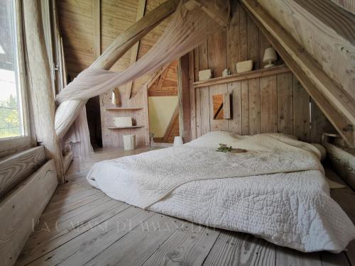 sypialnia z łóżkiem na drewnianym poddaszu w obiekcie La Cabane d' Emmanuelle, un Coin de paradis ! w mieście Saint-Nazaire