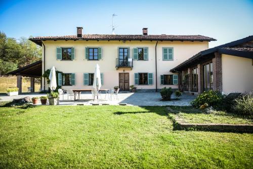 a large house with a patio and a yard at Cascina Lissona in Asti