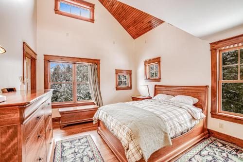 a bedroom with a bed and a dresser and windows at Around the Mountains in Chestertown
