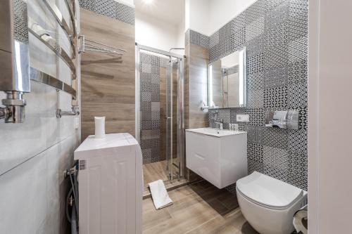 a white bathroom with a toilet and a sink at Grand Rynok Square apartment in Lviv