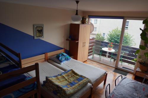 Zimmer mit 2 Betten, einem Tisch und einem Balkon in der Unterkunft Agroturystyka Willa Ola in Giewartów