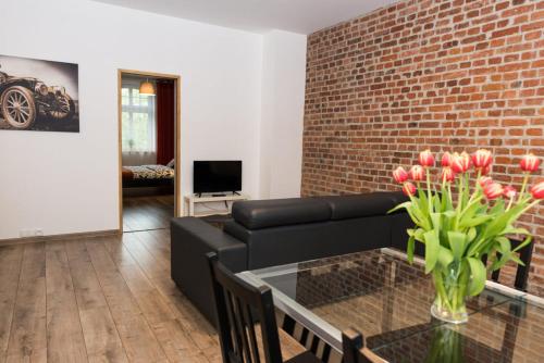 salon z czarną kanapą i ceglaną ścianą w obiekcie LEMON Apart w mieście Katowice